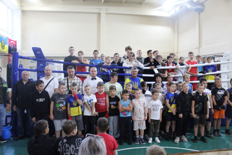 Спільне фото учасників турніру:  учасники, тренери, організатори стоять на фоні рингу. Частина дітей - на рингу.