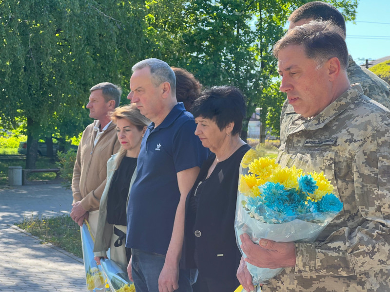 Спільне фото учасників заходу: керівництво міста та району, військові. Всі схилили голови, тримають квіти.  