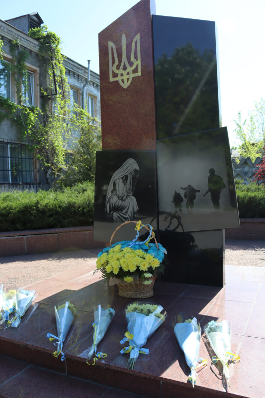 Пам'ятний знак загиблим захисникам і захисницям. У підніжжя - кошик із квітами, окремі букети.