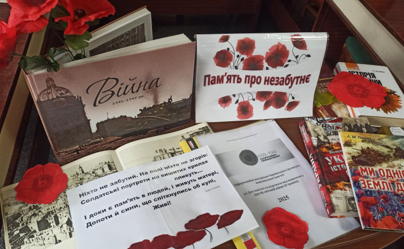 Книжкова виставка під назвою: "Пам'ять про незабутнє".  Тематичні книги  розмішені на  столі.  На окремих лежать квіти  - червоні маки. З однієї книги виглядає букетик із макових квіток.            