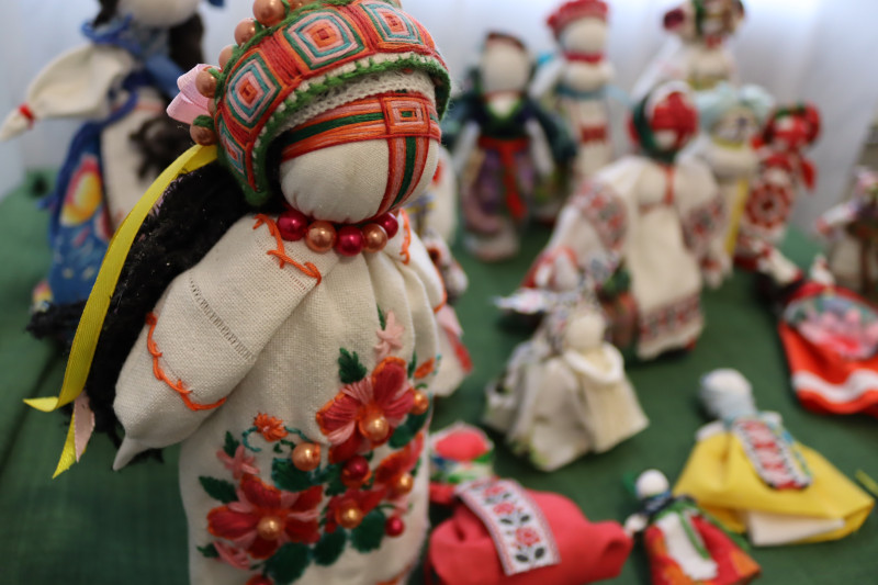 Різні ляльки-мотанки стоять на столі.