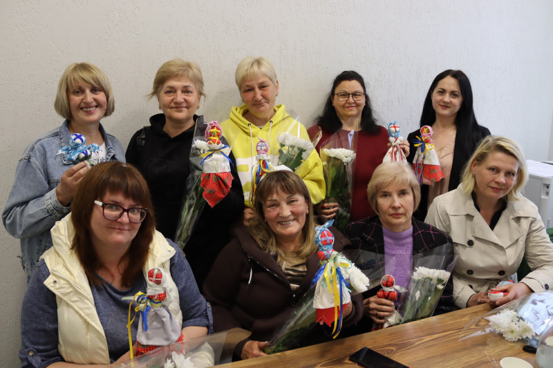 Спільне фото учасниць заходу. Усміхнені жінки тримають у руках квіти, власноруч виготовлених мотанок.