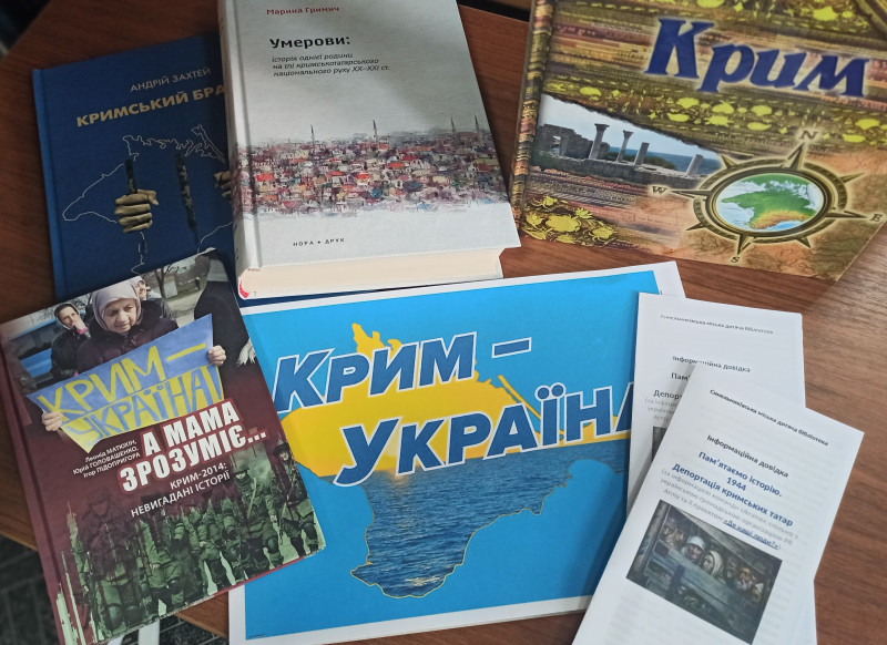 На столі лежать книги на тему: "Крим - Україна". 