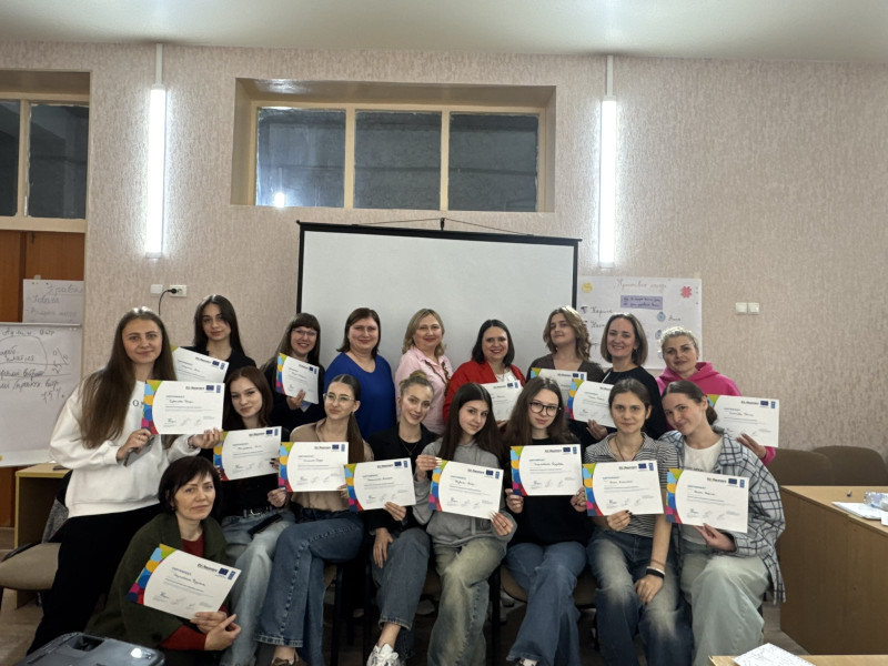 Спільне фото учасників заходу.  Два ряди. Одні стоять, інші - сидять. У руках тримають сертифікати. На обличчях  - усмішки.