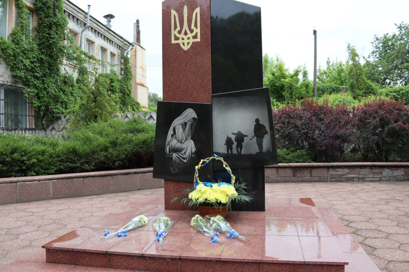 Пам'ятний знак на честь полеглих Захисників і Захисниць . У підніжжя - кошик із квітами, окремі букети.