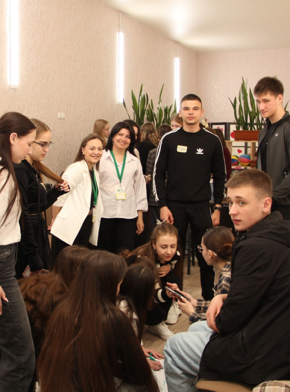 Робота  в групах: дівчата щось обговорюють, присівши, поруч - координаторки заходу, юнаки.   