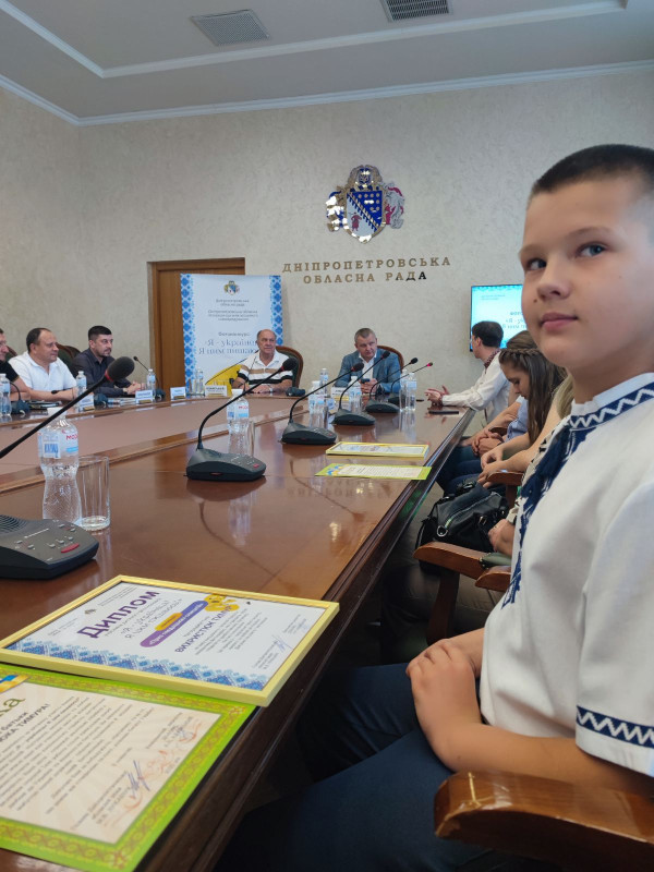 В залі Дніпропетровської обласної ради за столом сидать учасники конкурсу