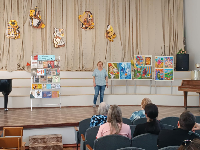 На сцені Синельниківської школи мистецтв виступ Вовк Світлани на фоні малюнків та книжкової виставки