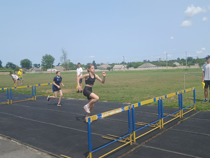 Дівчата на біговій доріжці долають бар'єри.