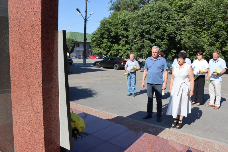 Міський голова Дмитро Зражевський та начальник Синельниківської районної військової адміністрації Світлана Назарчук схилили голови перед  пам'ятним  знаком на честь загиблих Героїв сучасності. За ними стоять інші представники міської та районної влади. 